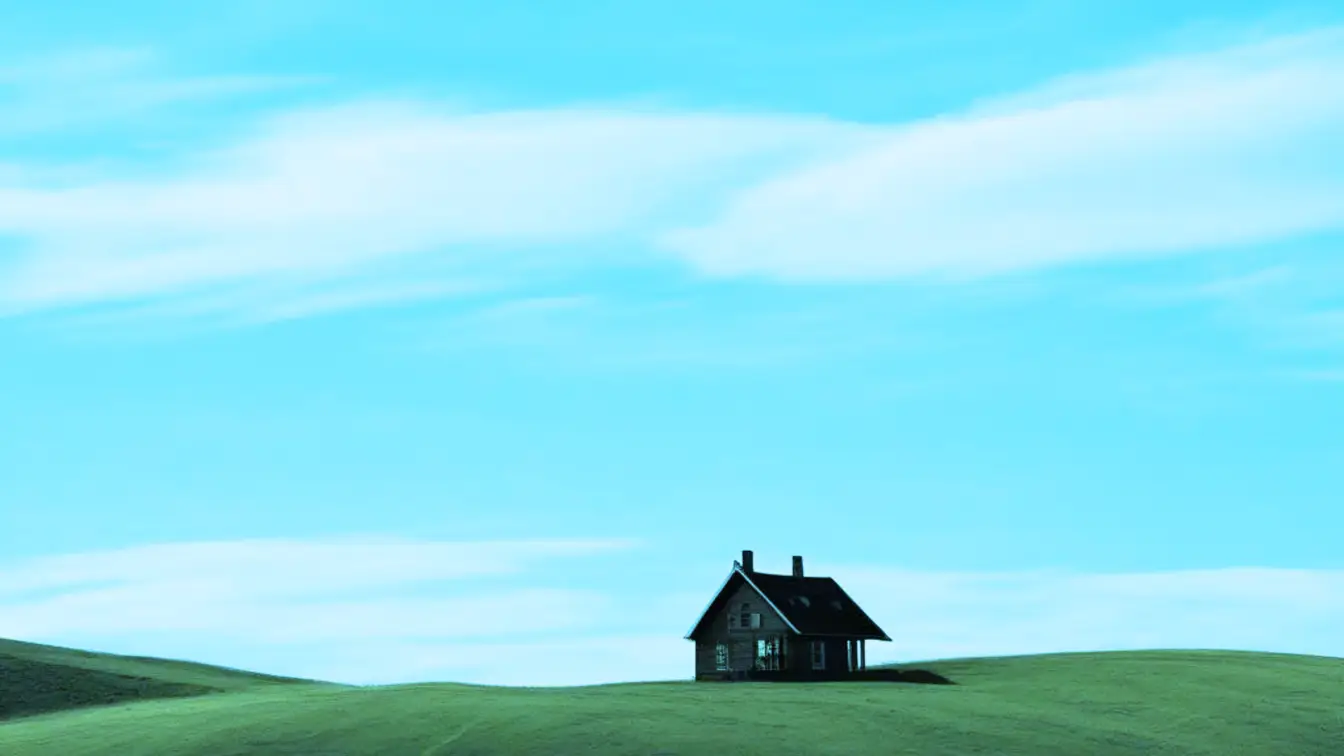 A house on a glassy plain. Big blue sky.